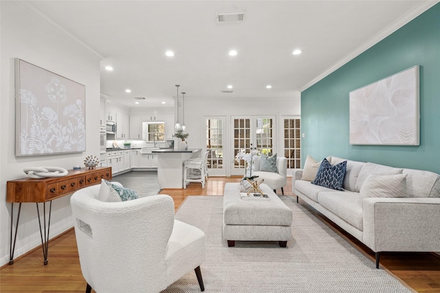 3803 Sunset Blvd, West University Place, TX 77005 - living area with ornamental molding, light wood-style floors, recessed lighting, and french doors