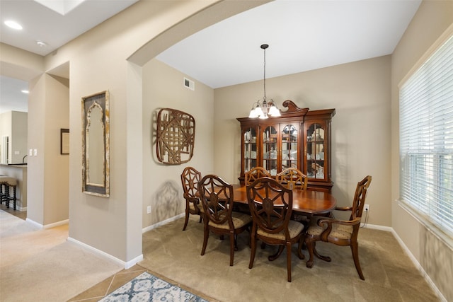 9135 Solvista Pass Ln, Houston, TX 77070 - tiled dining space with carpet floors, arched walkways, baseboards, and a chandelier