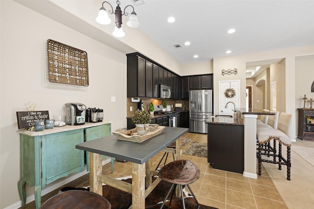 9135 Solvista Pass Ln, Houston, TX 77070 - kitchen with appliances with stainless steel finishes, a kitchen breakfast bar, light tile patterned floors, a sink, and recessed lighting
