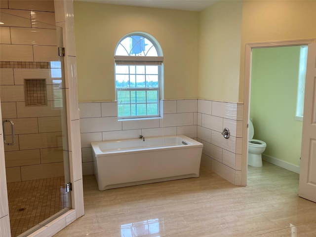 2709 Flores Bayou Bridge Rd, Angleton, TX 77515 - full bath with tile walls, a shower stall, a bath, toilet, and wainscoting