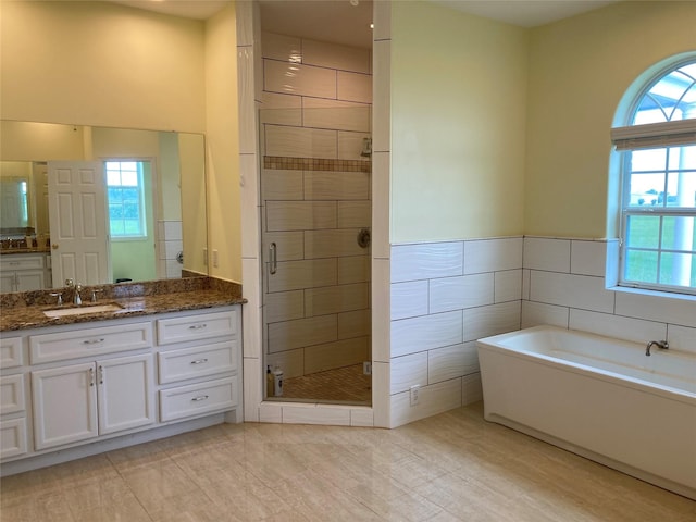 2709 Flores Bayou Bridge Rd, Angleton, TX 77515 - bathroom with a shower stall, vanity, a bath, and tile walls
