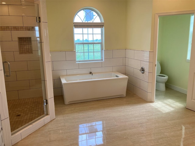 2709 Flores Bayou Bridge Rd, Angleton, TX 77515 - bathroom featuring a shower stall, a soaking tub, tile walls, toilet, and a wainscoted wall