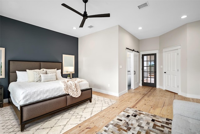 1728 Nicholson St, Houston, TX 77008 - bedroom with a barn door, wood finished floors, baseboards, recessed lighting, and ceiling fan