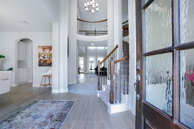 3207 Sweet Audrey Ln, Richmond, TX 77406 - foyer featuring stairway, arched walkways, wood finished floors, a chandelier, and baseboards