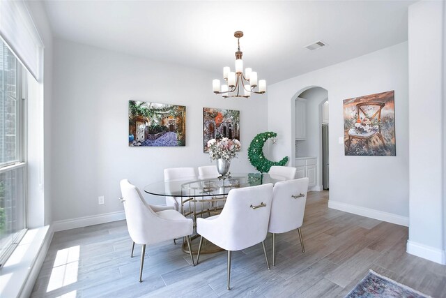 3207 Sweet Audrey Ln, Richmond, TX 77406 - dining space with arched walkways, wood finished floors, a chandelier, and baseboards