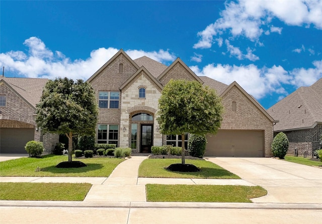 3207 Sweet Audrey Ln, Richmond, TX 77406 - french country home featuring driveway, a front yard, brick siding, an attached garage, and stone siding
