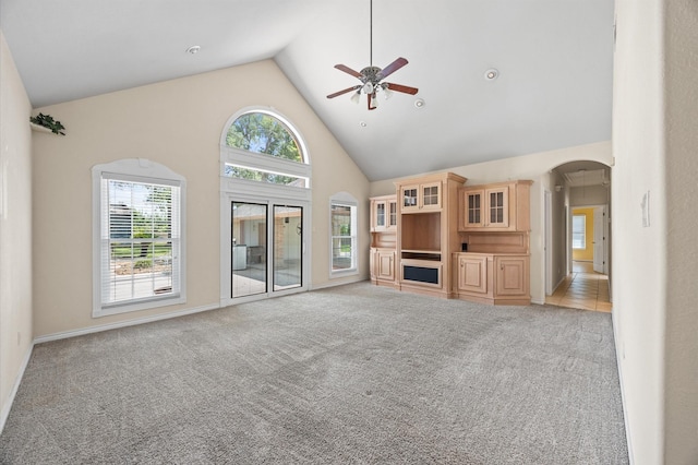 25187 Hill And Dale Ave, Splendora, TX 77372 - unfurnished living room with a ceiling fan, high vaulted ceiling, light carpet, arched walkways, and baseboards