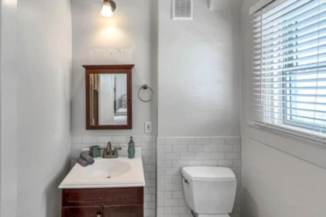 4204 Stanford St, Houston, TX 77006 - half bath featuring toilet, vanity, tile walls, and wainscoting