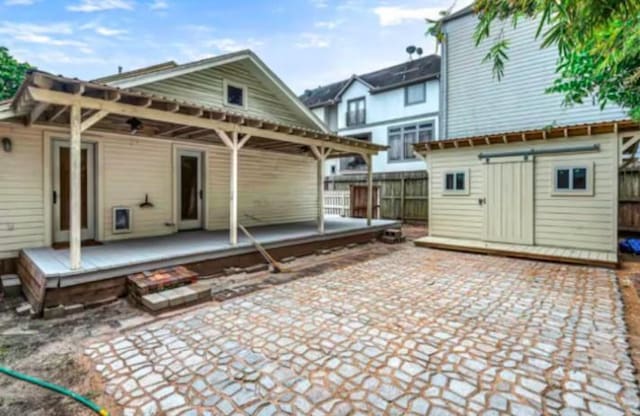 4204 Stanford St, Houston, TX 77006 - rear view of house with a patio, fence, and an outbuilding