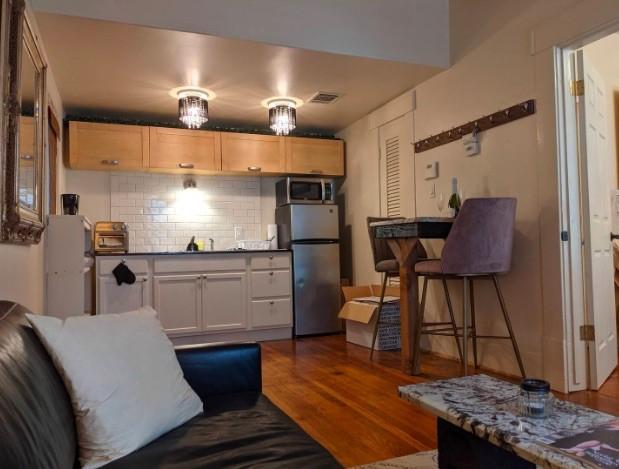 4204 Stanford St, Houston, TX 77006 - kitchen with appliances with stainless steel finishes, tasteful backsplash, dark wood-style floors, dark countertops, and a sink