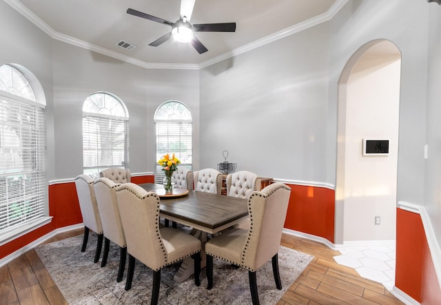 3010 Meadow Bay Dr, Dickinson, TX 77539 - dining room featuring light wood-style floors, crown molding, arched walkways, ceiling fan, and baseboards