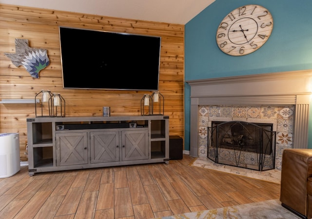 3010 Meadow Bay Dr, Dickinson, TX 77539 - living room featuring light wood-style floors, wood walls, and a tile fireplace