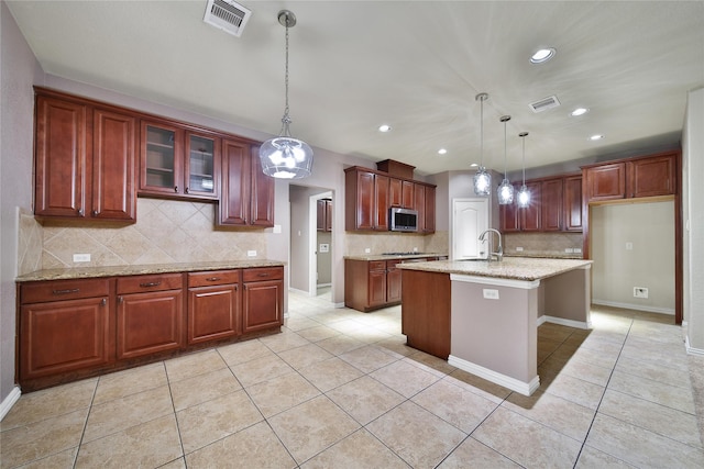 12119 Bayou Junction Rd, Cypress, TX 77433 - kitchen featuring stainless steel microwave, light tile patterned flooring, tasteful backsplash, decorative light fixtures, and recessed lighting