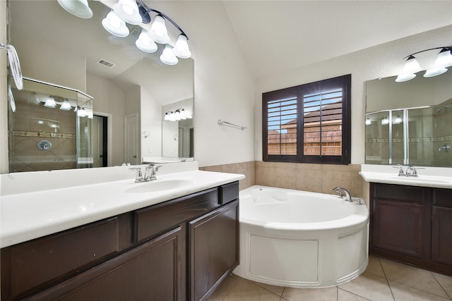 12119 Bayou Junction Rd, Cypress, TX 77433 - bathroom with vaulted ceiling, tile patterned floors, a stall shower, a bath, and two vanities