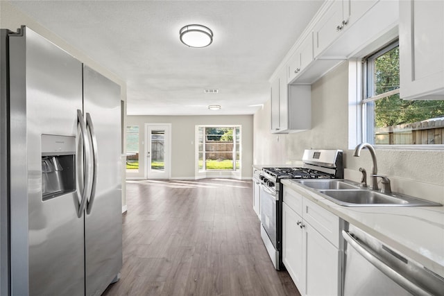 9110 Vickijohn Dr, Houston, TX 77031 - kitchen with appliances with stainless steel finishes, a sink, dark wood-style floors, light countertops, and white cabinetry