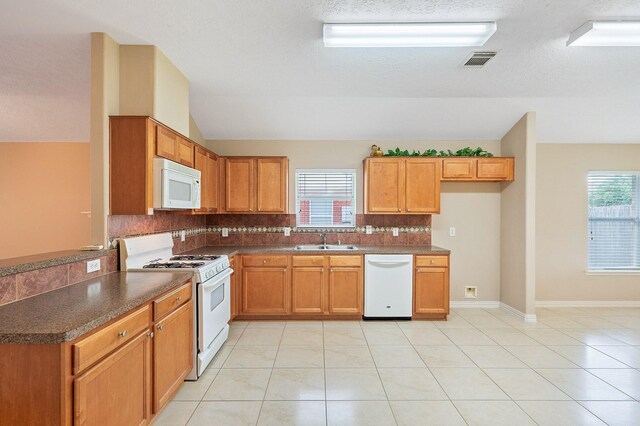 20130 Laramie River Trl, Katy, TX 77449 - kitchen featuring white appliances, a sink, backsplash, dark countertops, and lofted ceiling