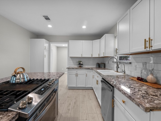 618 Forest Lake Dr, Seabrook, TX 77586 - kitchen featuring stainless steel appliances, a sink, white cabinetry, stone counters, and light wood-style floors