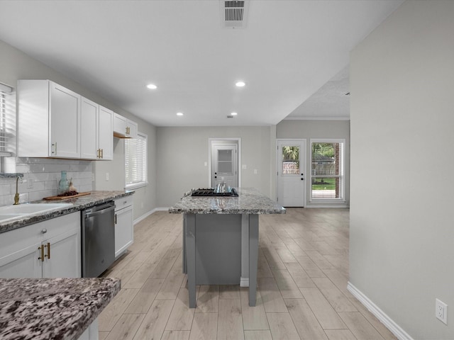 618 Forest Lake Dr, Seabrook, TX 77586 - kitchen with dishwasher, baseboards, white cabinets, a center island, and tasteful backsplash