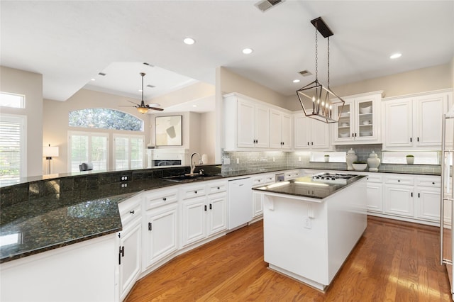 5819 Desert Oak Way, Spring, TX 77379 - kitchen featuring white dishwasher, a sink, white cabinets, light wood-style floors, and backsplash