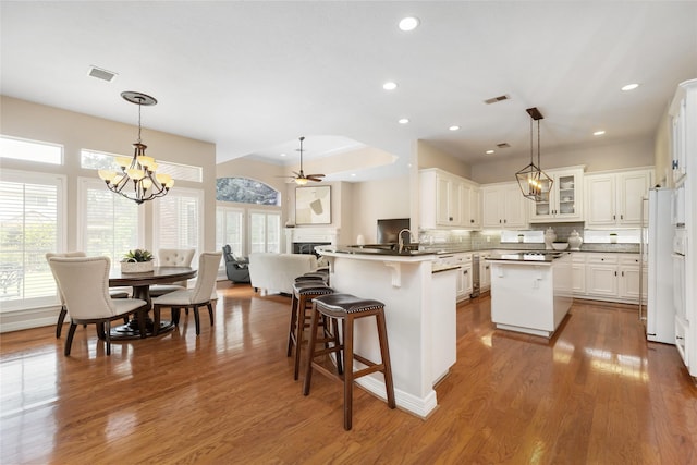 5819 Desert Oak Way, Spring, TX 77379 - kitchen with a chandelier, a fireplace, tasteful backsplash, open floor plan, and a peninsula