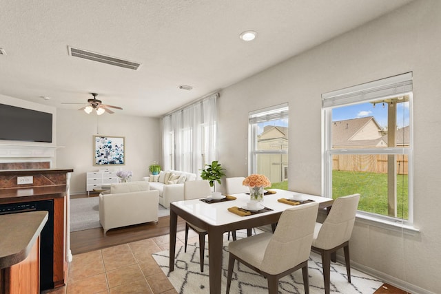 6010 Twin Crk, Missouri City, TX 77459 - dining space with a fireplace, ceiling fan, and light tile patterned flooring