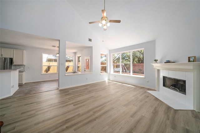 2111 Scenic Hollow Ct, Katy, TX 77450 - unfurnished living room with ceiling fan, wood finished floors, a fireplace, high vaulted ceiling, and baseboards