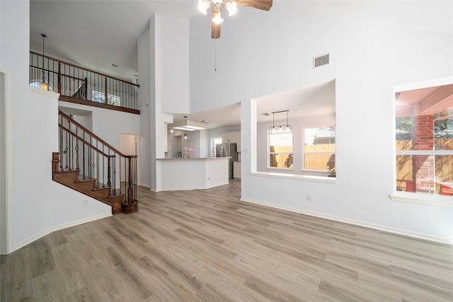 2111 Scenic Hollow Ct, Katy, TX 77450 - unfurnished living room featuring a ceiling fan, wood finished floors, stairway, a high ceiling, and baseboards