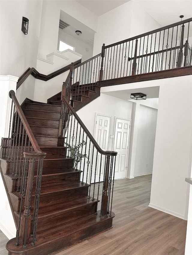 2111 Scenic Hollow Ct, Katy, TX 77450 - stairs featuring wood finished floors, a high ceiling, and baseboards