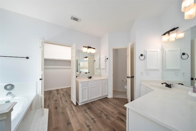 2111 Scenic Hollow Ct, Katy, TX 77450 - full bathroom with wood finished floors, toilet, a bath, and a spacious closet