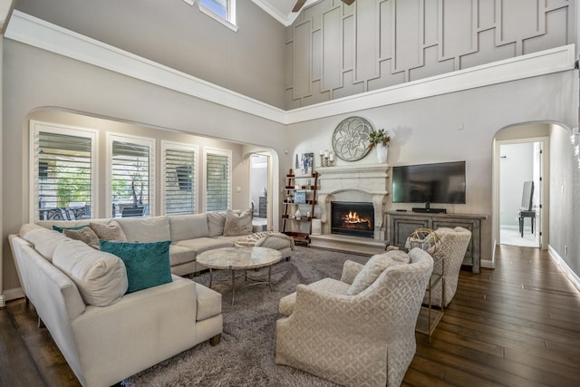 20103 Kirkstone Terrace Ct, Spring, TX 77379 - living area featuring a high ceiling, arched walkways, dark wood finished floors, a lit fireplace, and baseboards