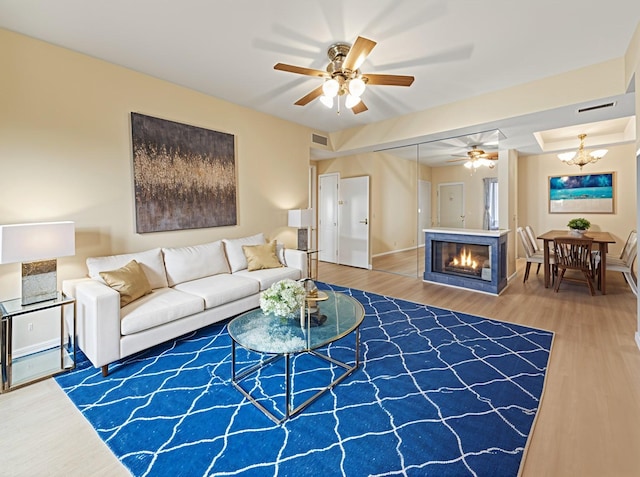 8055 Cambridge St Unit 21, Houston, TX 77054 - living area with ceiling fan, wood finished floors, baseboards, and a glass covered fireplace