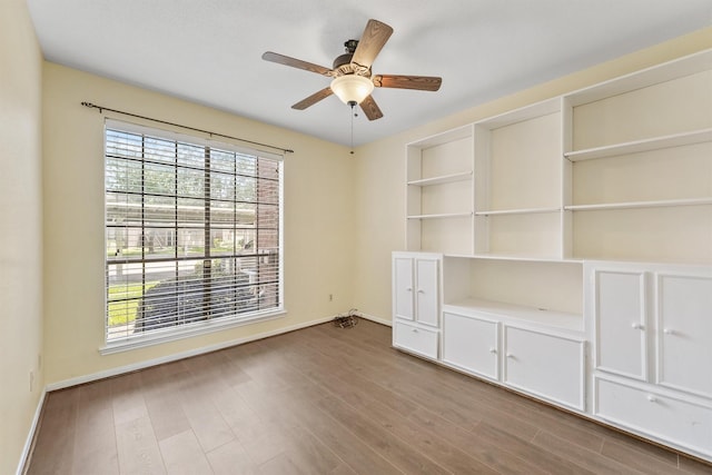 8055 Cambridge St Unit 21, Houston, TX 77054 - spare room featuring baseboards, wood finished floors, a ceiling fan, and built in shelves