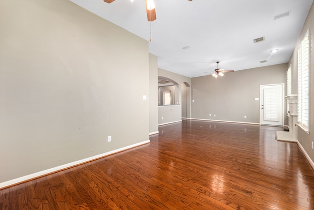 10446 Antelope Aly, Missouri City, TX 77459 - unfurnished living room featuring ceiling fan, arched walkways, wood finished floors, and baseboards