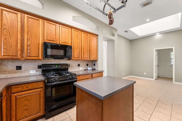 10446 Antelope Aly, Missouri City, TX 77459 - kitchen with black appliances, a skylight, dark countertops, light tile patterned floors, and recessed lighting