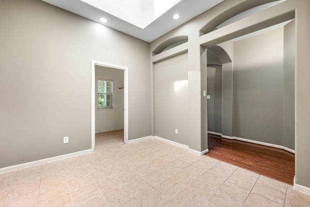 10446 Antelope Aly, Missouri City, TX 77459 - empty room with light tile patterned floors, arched walkways, recessed lighting, and baseboards