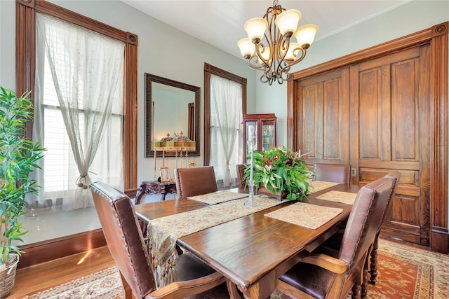 2608 Ursuline St, Galveston, TX 77550 - dining area with a chandelier, wood finished floors, and baseboards