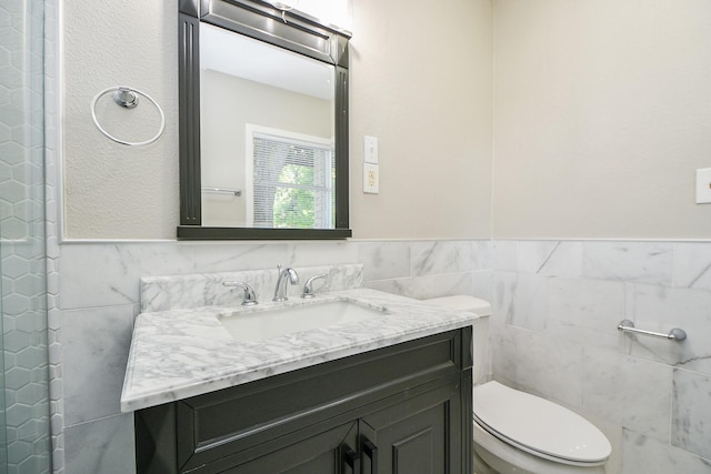 1225 Kirsten St, Galveston, TX 77568 - bathroom with tile walls, toilet, vanity, and a wainscoted wall