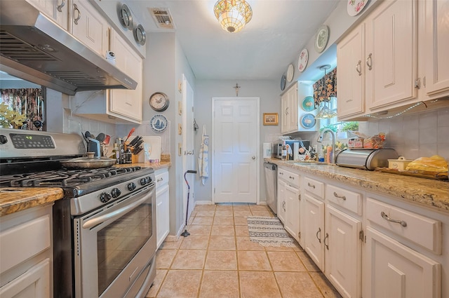 30926 Hilltop Ln, Magnolia, TX 77354 - kitchen with appliances with stainless steel finishes, under cabinet range hood, a sink, and decorative backsplash
