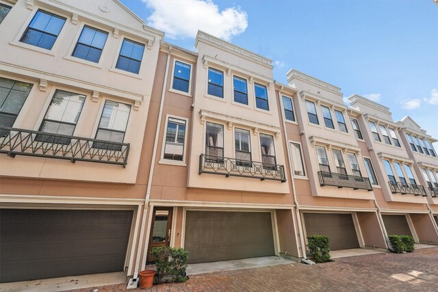 3302 Audley St Unit 110, Houston, TX 77098 - back of house featuring a garage, driveway, and stucco siding