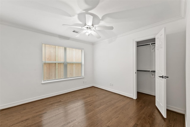 unfurnished bedroom featuring ornamental molding, dark wood-type flooring, a closet, ceiling fan, and baseboards