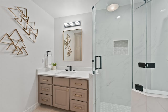 bathroom featuring a marble finish shower, vanity, and baseboards