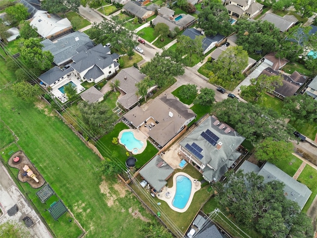 aerial view of property and surrounding area with a pool area and nearby suburban area