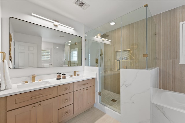 full bathroom with a shower stall, double vanity, and a garden tub