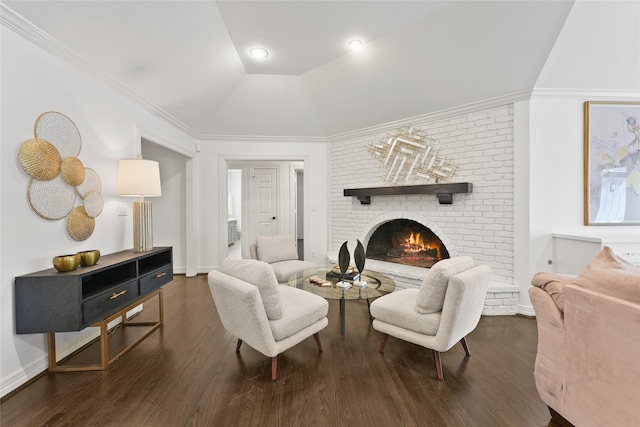 living room featuring wood finished floors, a brick fireplace, lofted ceiling, and baseboards