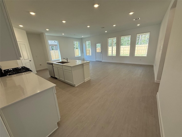 503 Shoreview Dr, Conroe, TX 77303 - kitchen with a sink, baseboards, light countertops, an island with sink, and light wood finished floors