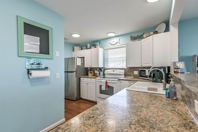 4606 Jamaica Cove Rd, Jamaica Beach, TX 77554 - kitchen featuring white electric range oven, freestanding refrigerator, a sink, white cabinets, and backsplash