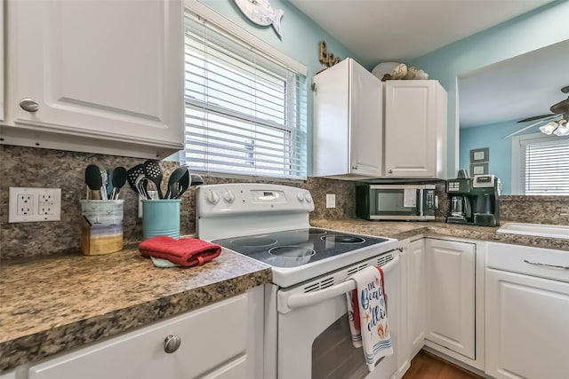 4606 Jamaica Cove Rd, Jamaica Beach, TX 77554 - kitchen with white electric stove, stainless steel microwave, and white cabinetry