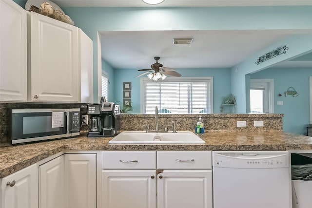 4606 Jamaica Cove Rd, Jamaica Beach, TX 77554 - kitchen with white dishwasher, stainless steel microwave, a sink, a ceiling fan, and white cabinetry
