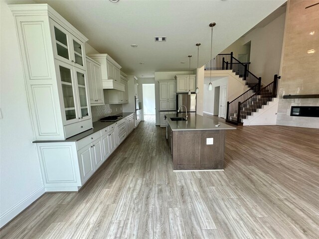 1215 Tallow Park Ln, Pinehurst, TX 77362 - kitchen featuring stovetop, freestanding refrigerator, light wood-style flooring, and a sink