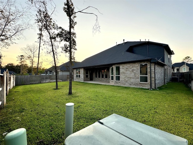 1215 Tallow Park Ln, Pinehurst, TX 77362 - back of house at dusk with a patio area and brick siding